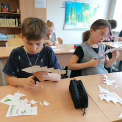 Bērni darbojas ar šķērēm.