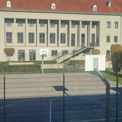 Sporta laukums pie Mittelschule St. Veit, kur notiek sporta stundas un skolēni pavada starpbrīžus.