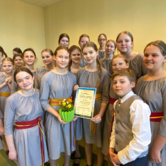 Kora meitenes tur rokās iegūto diplomu par augstāko pakāpi.