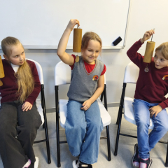 Bērni ar zvaniņiem rokās.