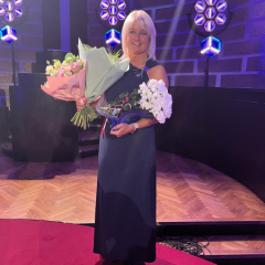 Skolotāja Lāsma Rumpe ar balvu un ziediem