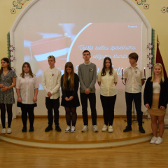 8.b klases skolēni uz skatuves sveic Latviju 105.gadadienā.