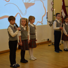 Uz skatuves mazāko klašu skolēni ar apsveikuma runu Latvijai.