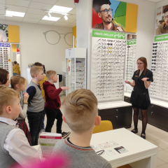 Optikas salona darbiniece bērniem  stāsta par savu profesiju