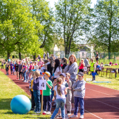 Dalībnieki nostājušies stadionā uz pasākuma atklāšanu.