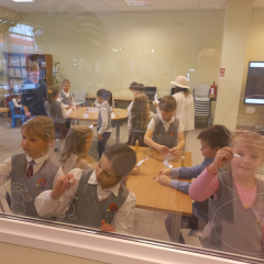 Bērni ar marķieri glezno uz loga.